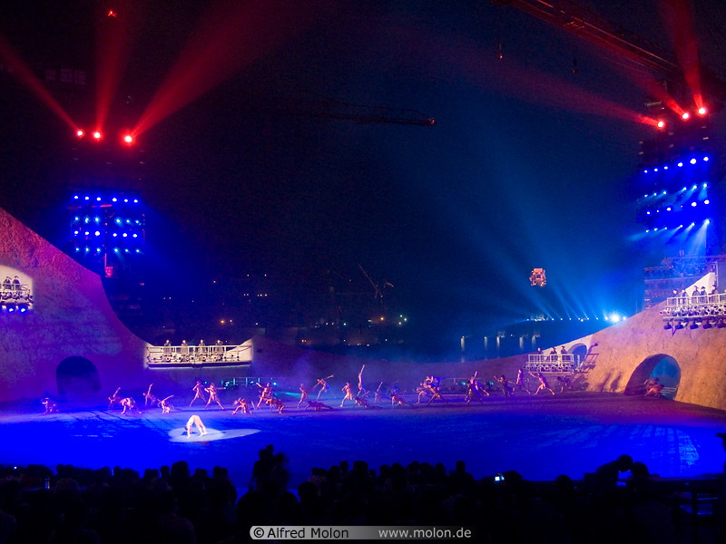 13 Dancers on stage illuminated with blue light
