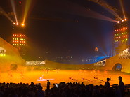 14 Dancers on stage illuminated with orange light