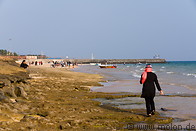 02 Woman walking along beach rocks