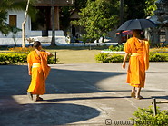 15 Buddhist monks walking with an umbrella