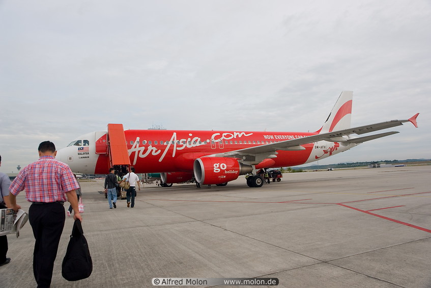 11 Travellers boarding red AirAsia jet