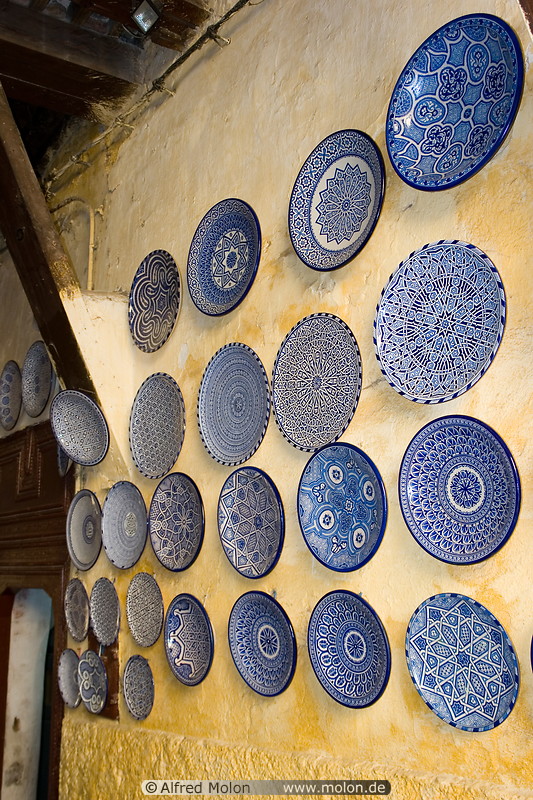 12 Decorated blue plates on yellow wall