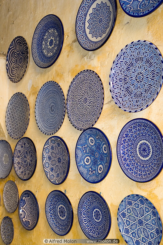 13 Decorated blue plates on yellow wall