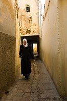 20 Woman wearing hijab walking in narrow alley