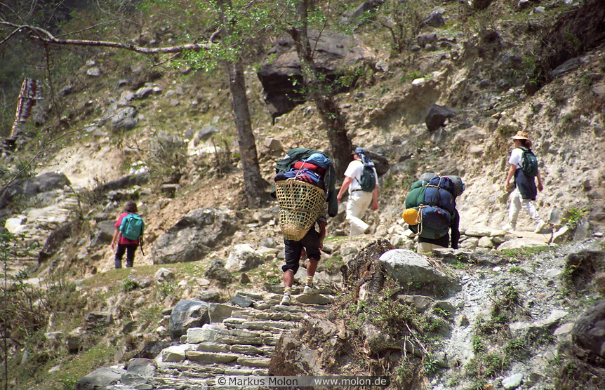 17 Two porters carrying the bags of three Sunday tourists