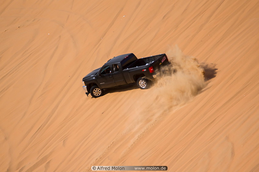 16 Pickup truck driving on sand dune